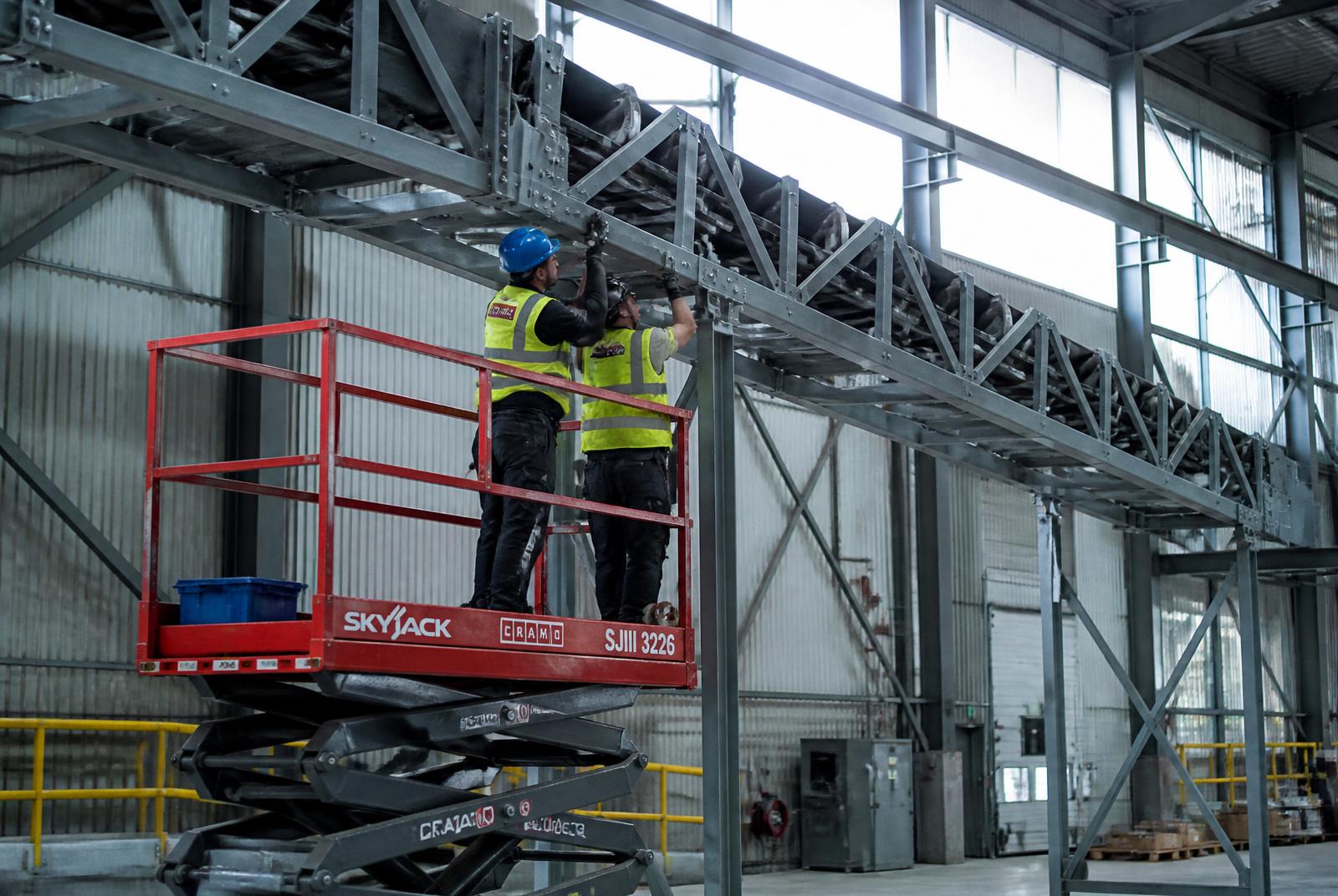 To montører monterer en stålkonstruktion fra en lift
